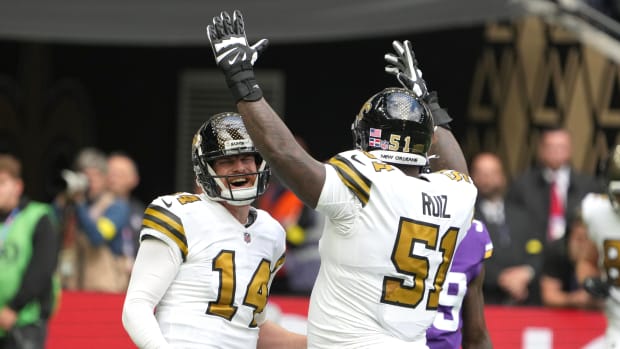 Andy Dalton (14) and center Cesar Ruiz (51) celebrate